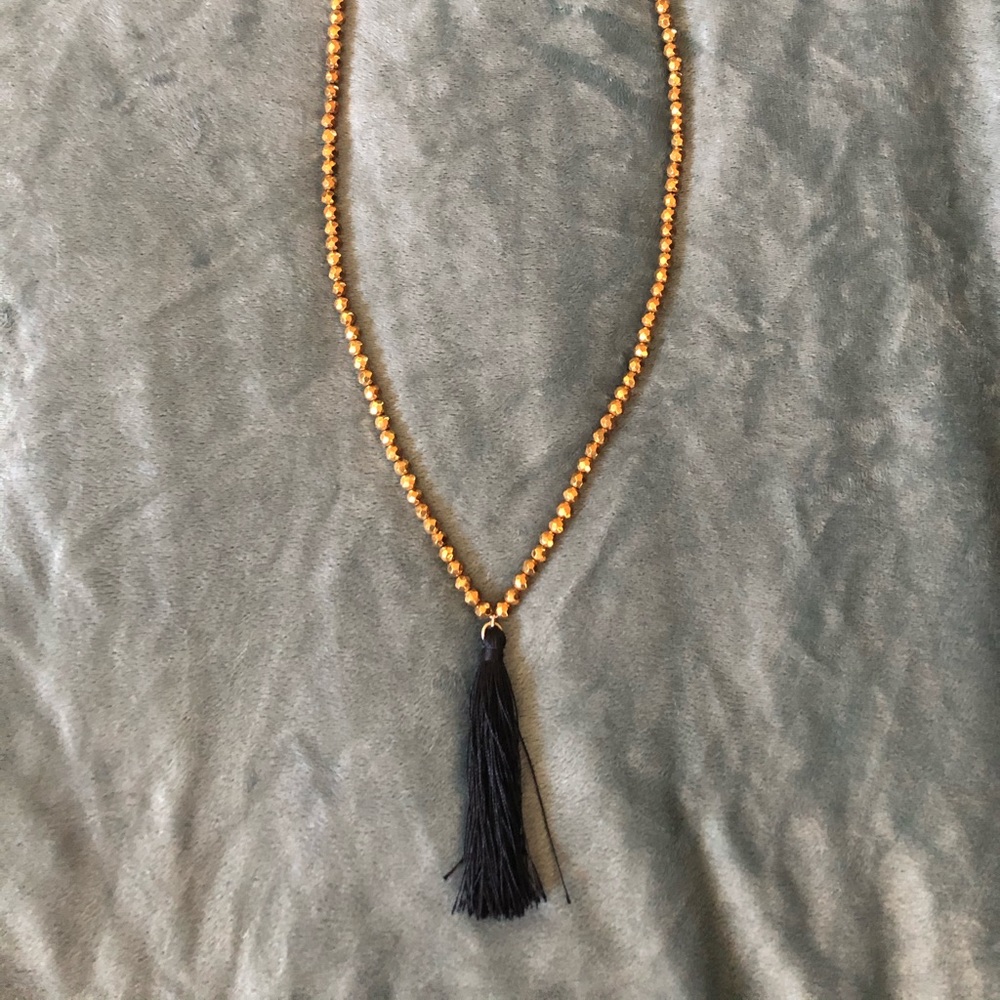 Gold beaded necklace with black tassel